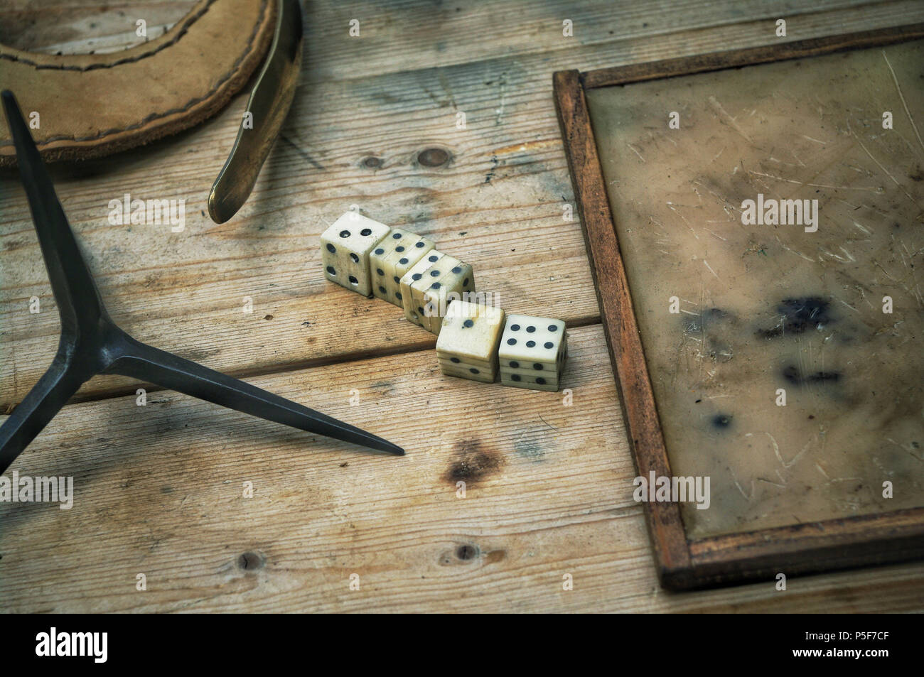 Roman bone dice and a wax writing tablet on a table. Stock Photo