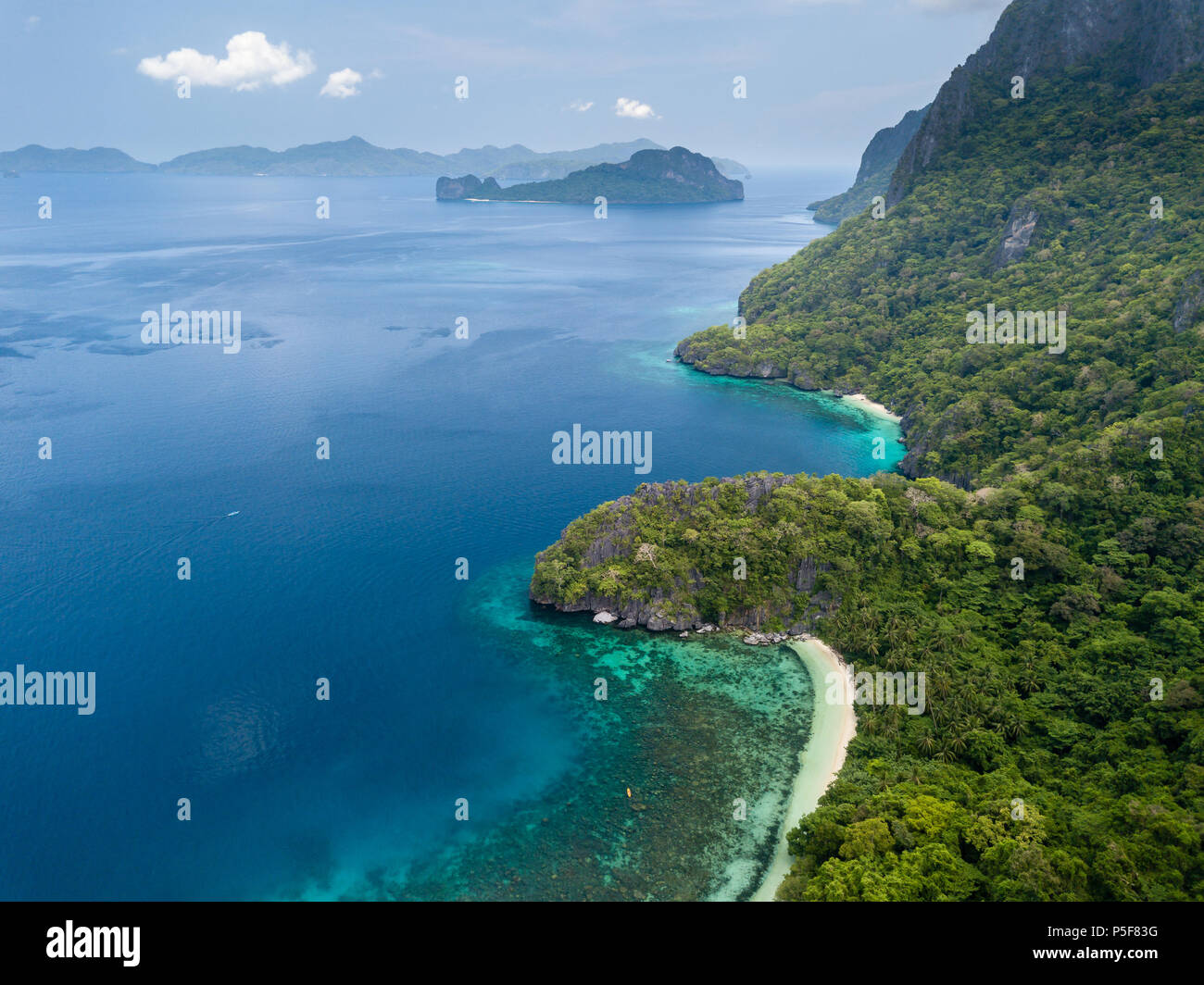 Aerial drone view of a tropical island, surrounding coral reefs, jungle and beaches Stock Photo