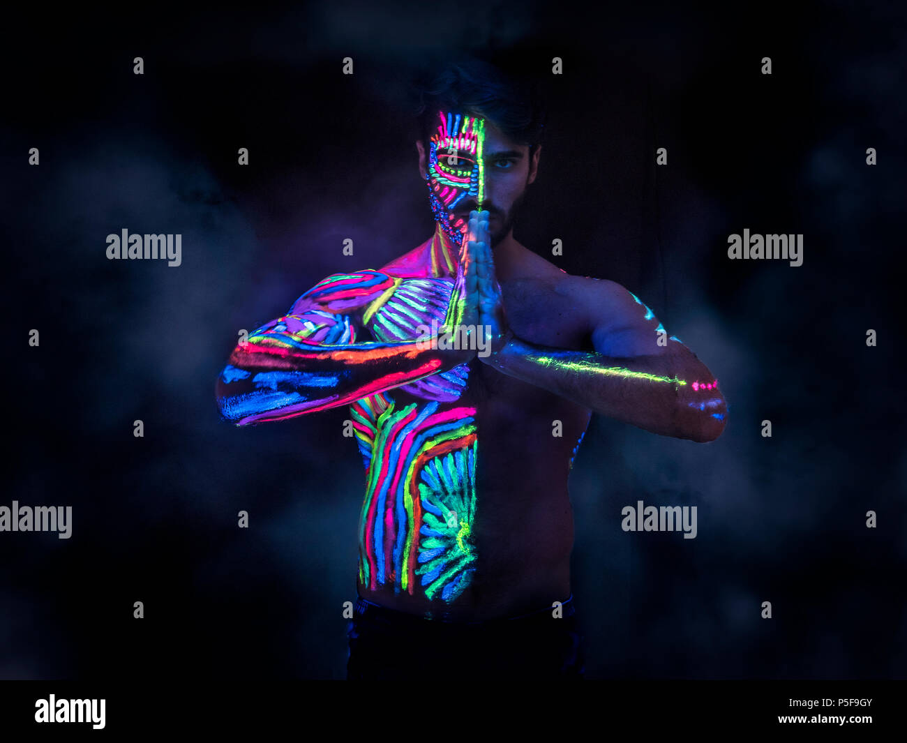 Young man painted in fluorescent paint Stock Photo