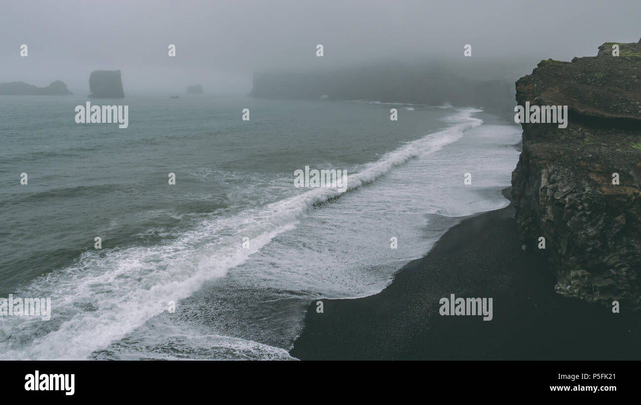 coast with black sand beach and big waves. Foggy coastlines shoreline Stock Photo