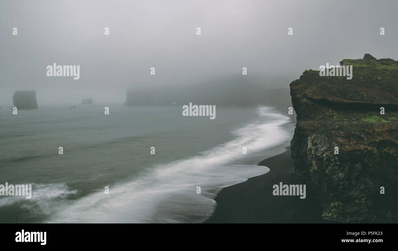 coast with black sand beach and big waves. Foggy coastlines shoreline Stock Photo