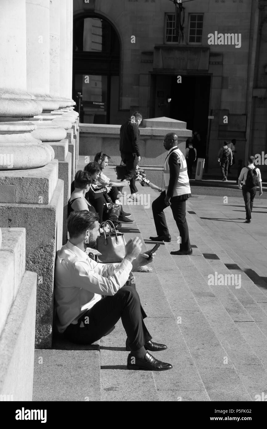 Office workers relaxing on the steps of The Royal Exchange (a luxury shopping centre above Bank station), London, England, UK, PETER GRANT Stock Photo