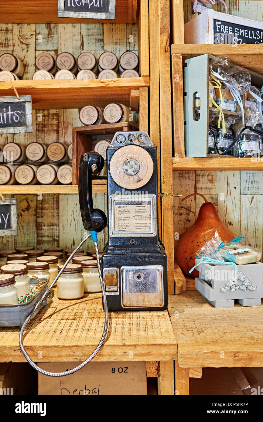Mid 1960s or 1970s dial pay telephone or payphone on display in a country roadside store or market in Pike Road Alabama, USA. Stock Photo