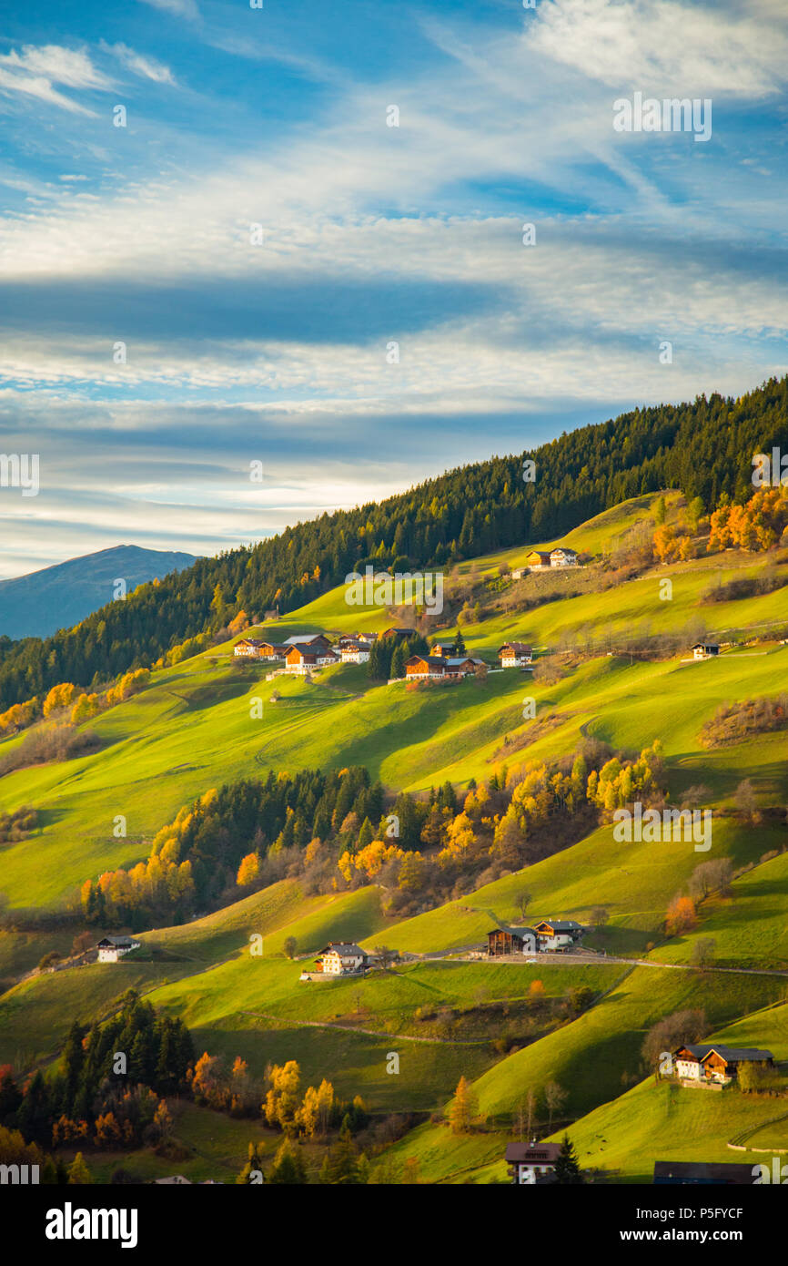 Beautiful view of idyllic mountain scenery with green meadows in the Dolomites in beautiful golden evening light at sunset, Val di Funes, South Tyrol, Stock Photo