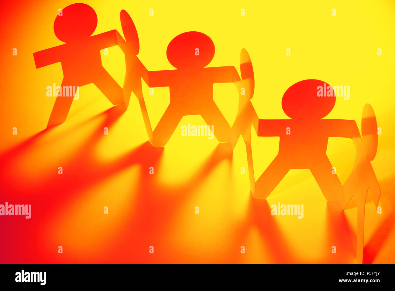 Team of paper chain people in a row holding hands Stock Photo - Alamy