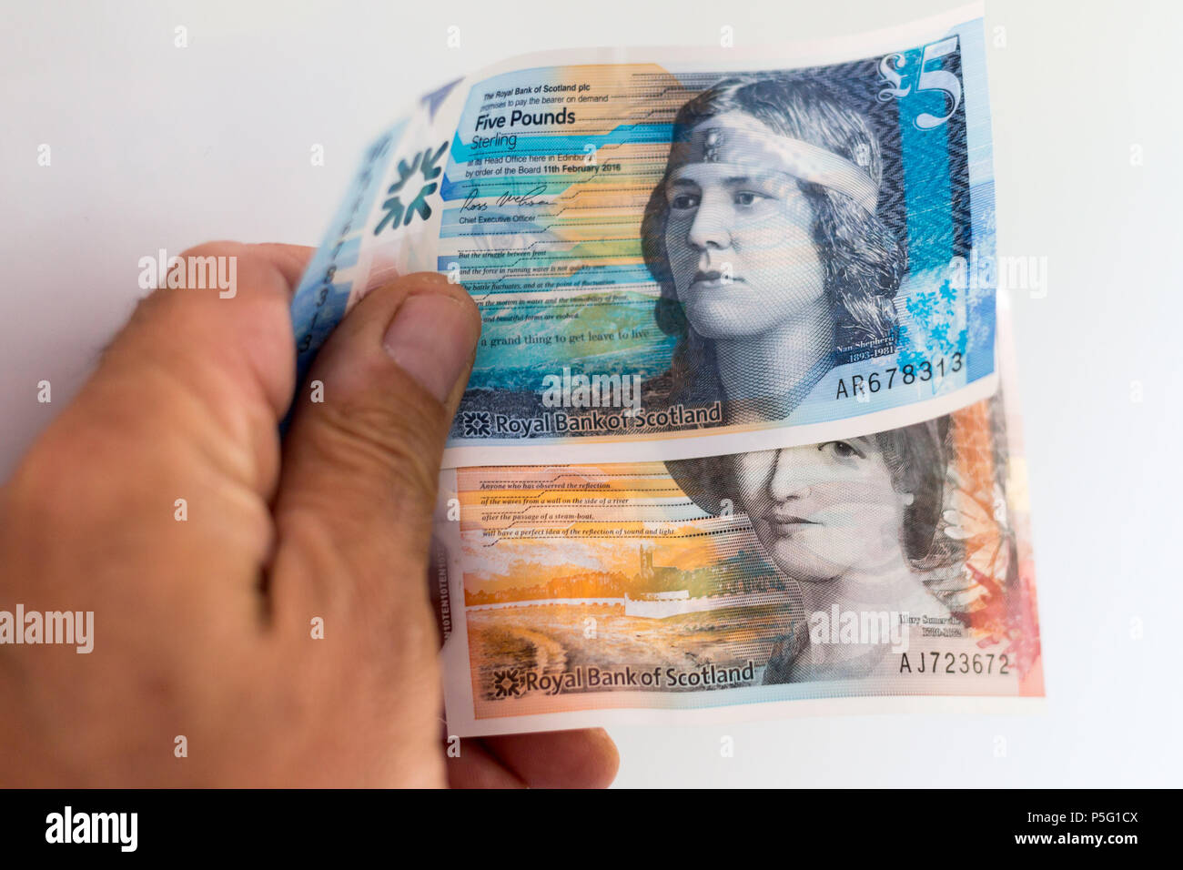 Scottish paper currency 5 and 10 pound notes, royal bank of scotland being held in mans hand Stock Photo