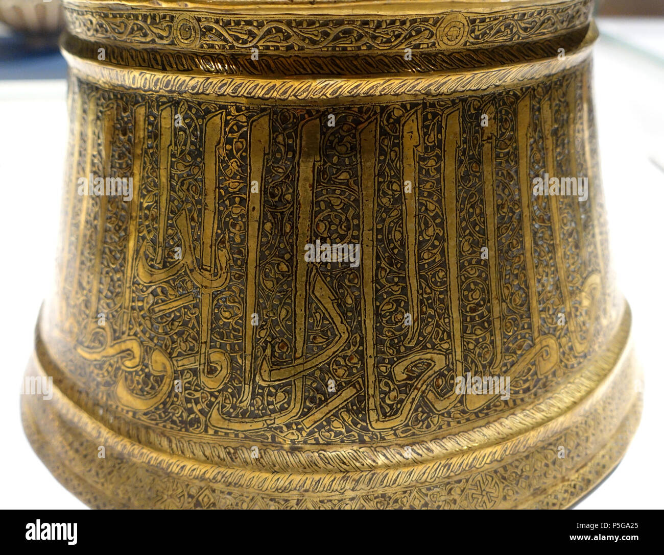 N/A. English: Exhibit in the Aga Khan Museum - Toronto, Canada. This work is old enough so that it is in the . Photography was permitted in the museum without restriction. 6 October 2015, 12:19:05. Daderot 267 Candlestick with Solos script, Iran, mid to late 14th century AD, brass, formerly inlaid with silver and gold, view 2 - Aga Khan Museum - Toronto, Canada - DSC06710 Stock Photo