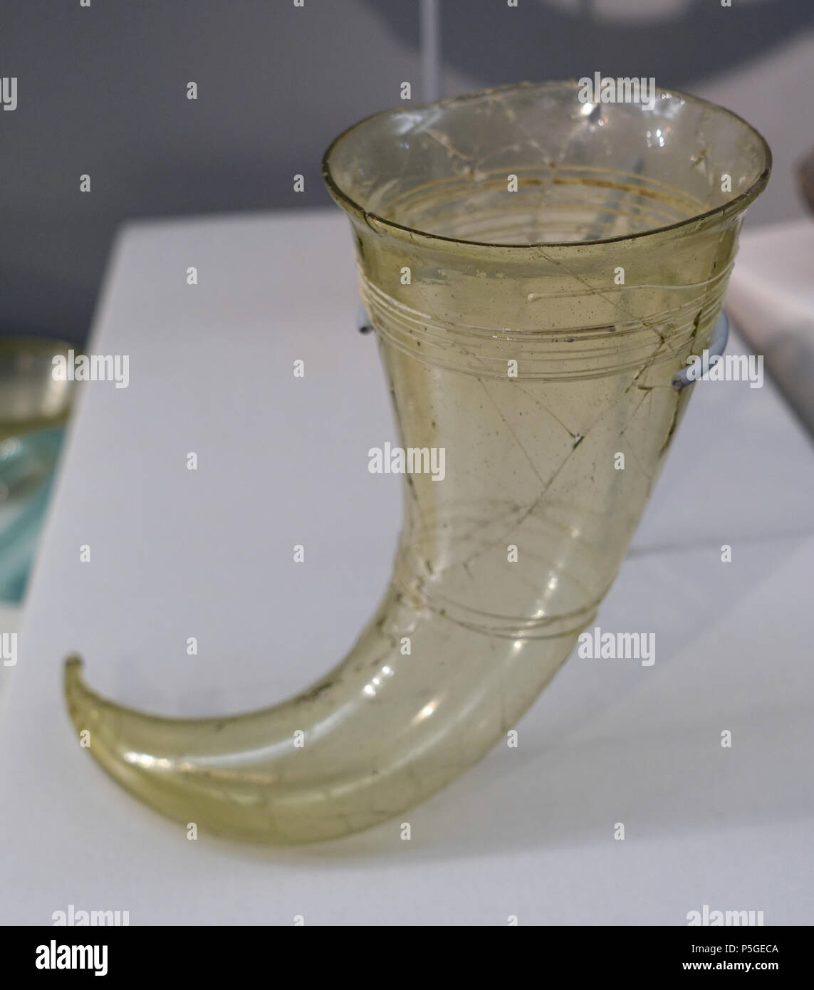 N/A. English: Exhibit in the Cinquantenaire Museum - Brussels, Belgium. 22 April 2016, 07:42:12. Daderot 480 Drinking horn, tomb 250, Bossut-Gottechain, Brabant, 530-570 AD, glass DSC08767 Stock Photo