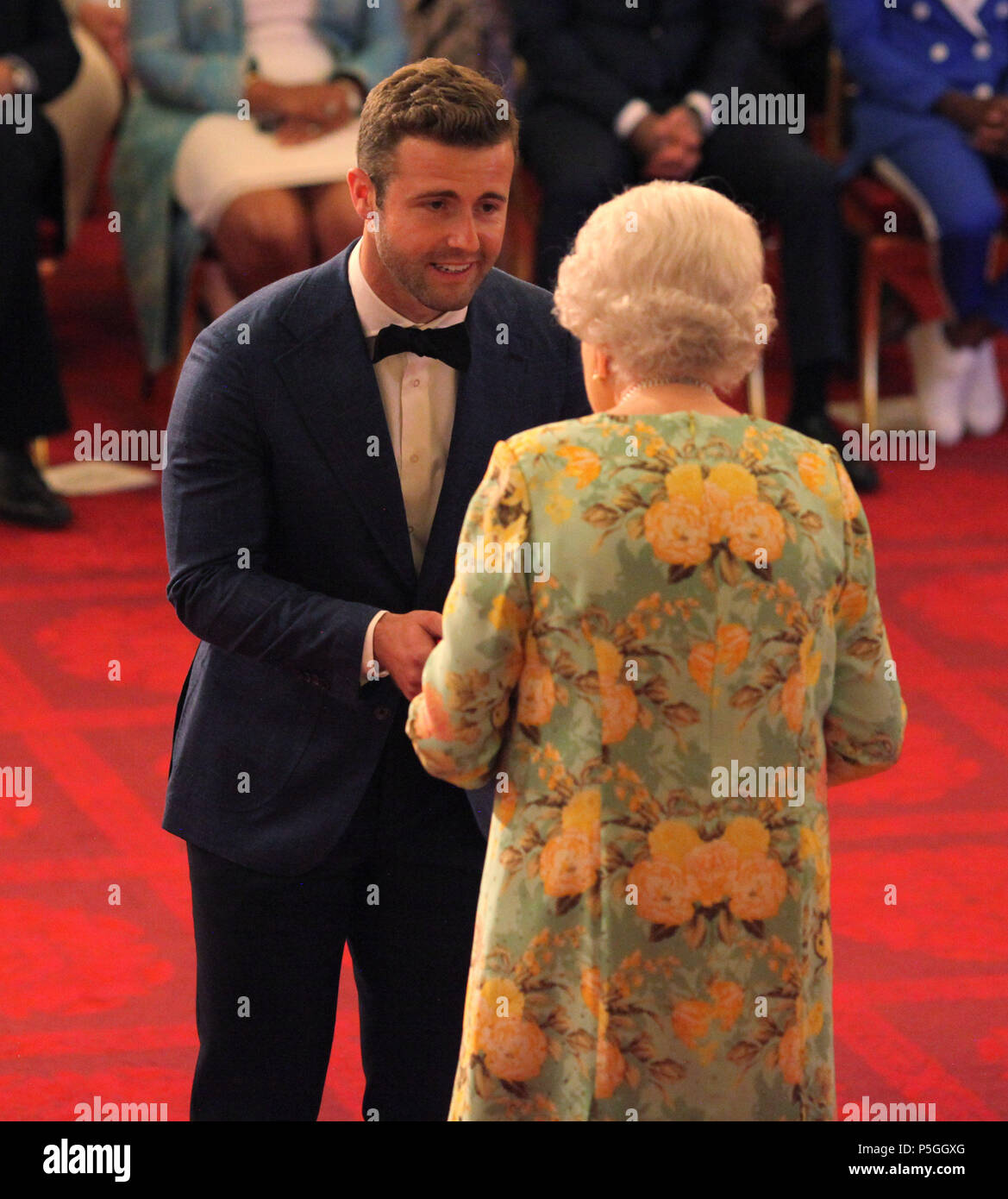 Mr. Hunter Johnson from Australia receives his Young Leaders Award from Queen Elizabeth II during a ceremony in the Ballroom at Buckingham Palace. Stock Photo