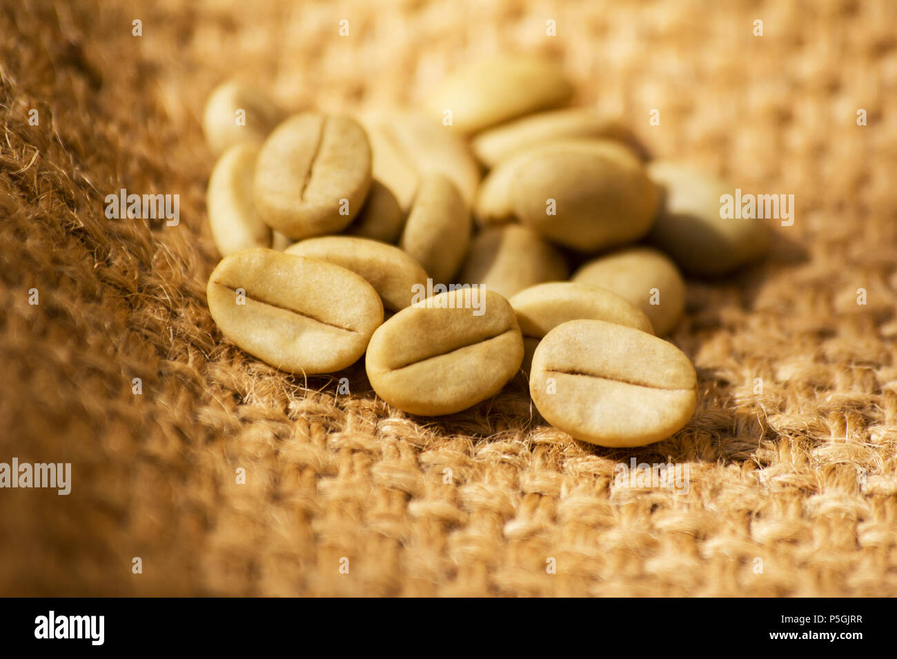 Green coffee beans on burlap Stock Photo