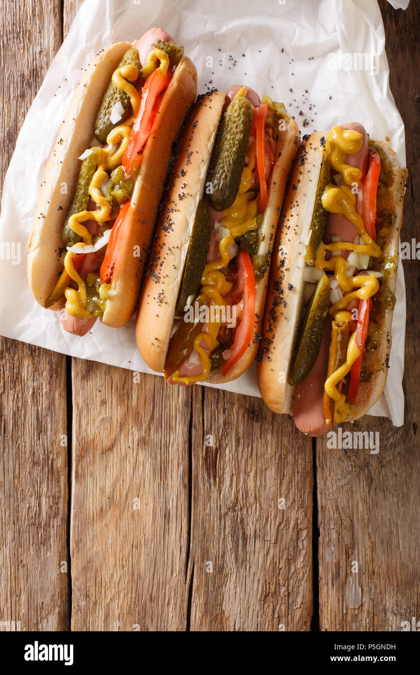 Chicago style hot dog with mustard, tomatoes, pickled cucumbers, onions