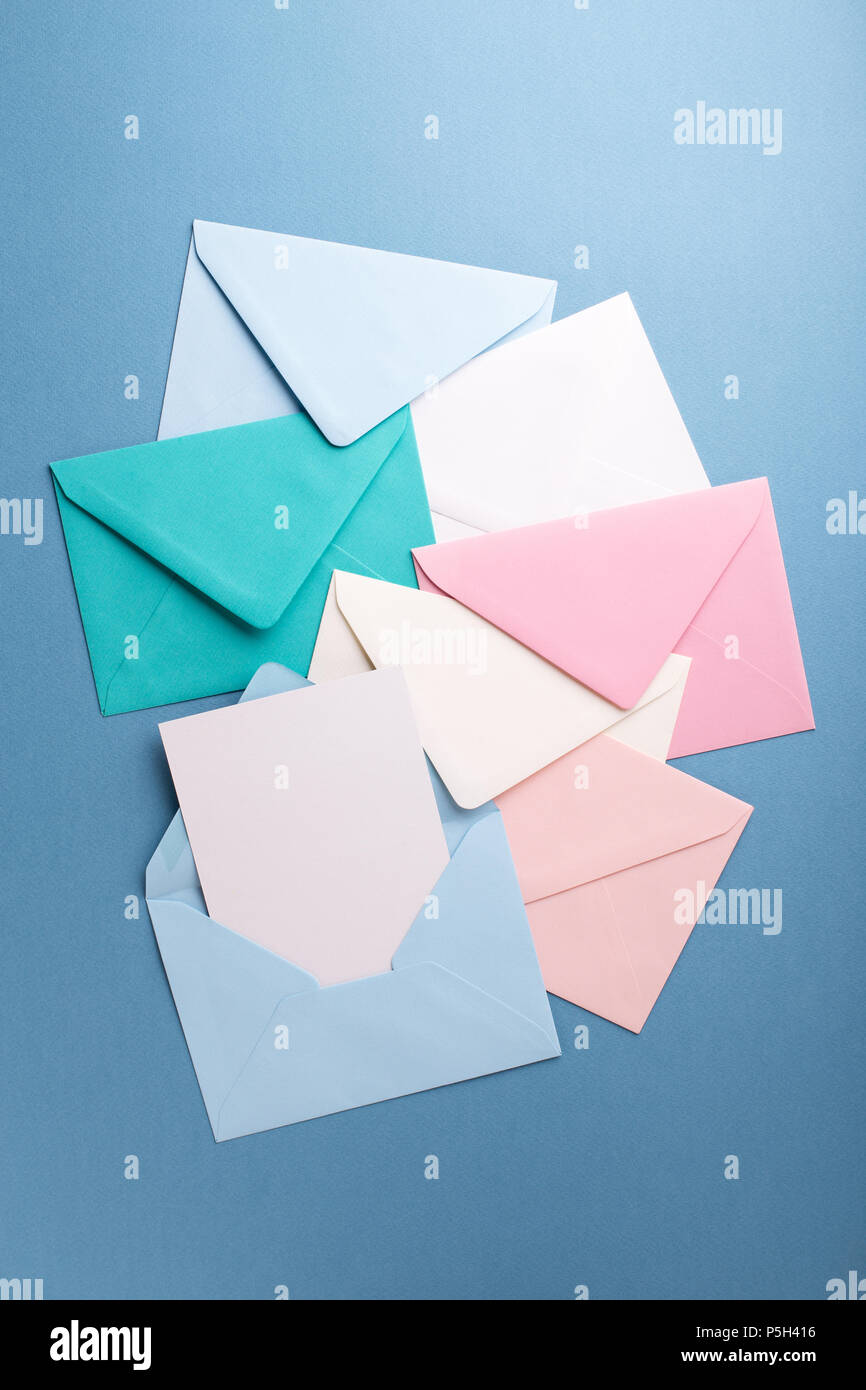 Group of colorful envelopes on grey table with empty card. Correspondence concept. Mockup. Stock Photo