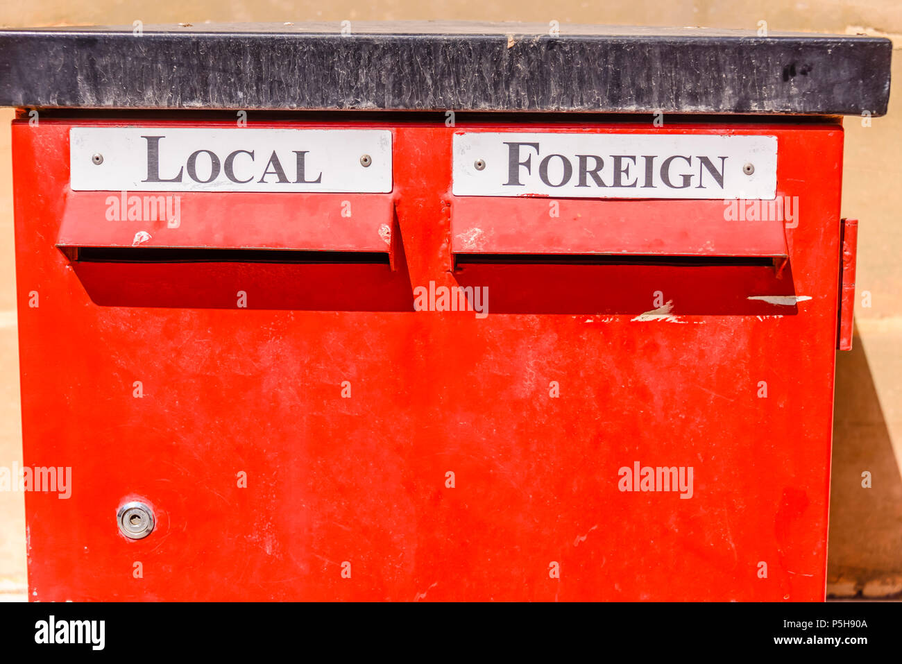 Red letterbox with slots for local and foreign mail. Stock Photo
