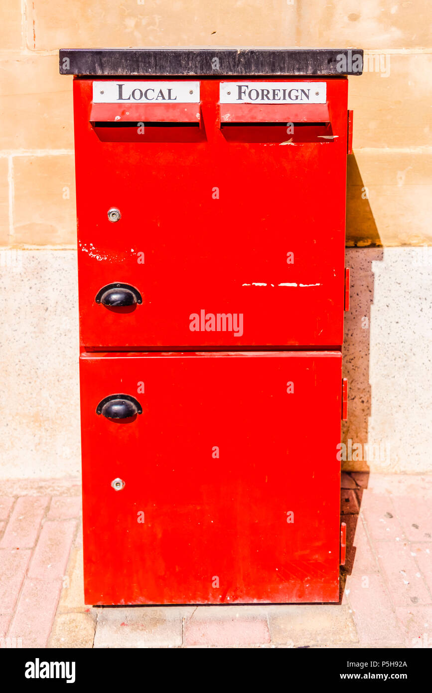 Red letterbox with slots for local and foreign mail. Stock Photo