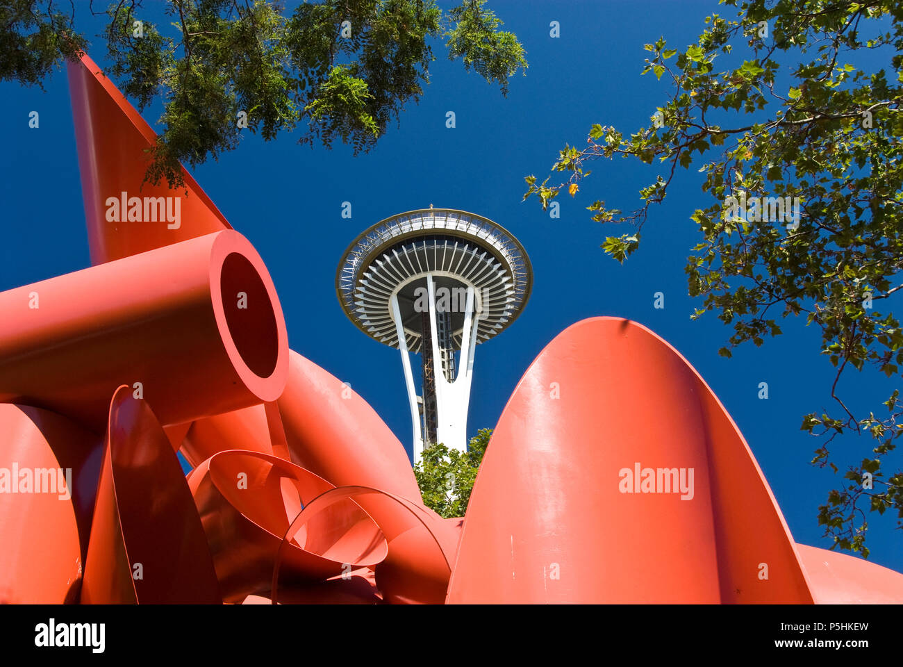 A large red modern art piece stands on a path to the Space Needle (rear