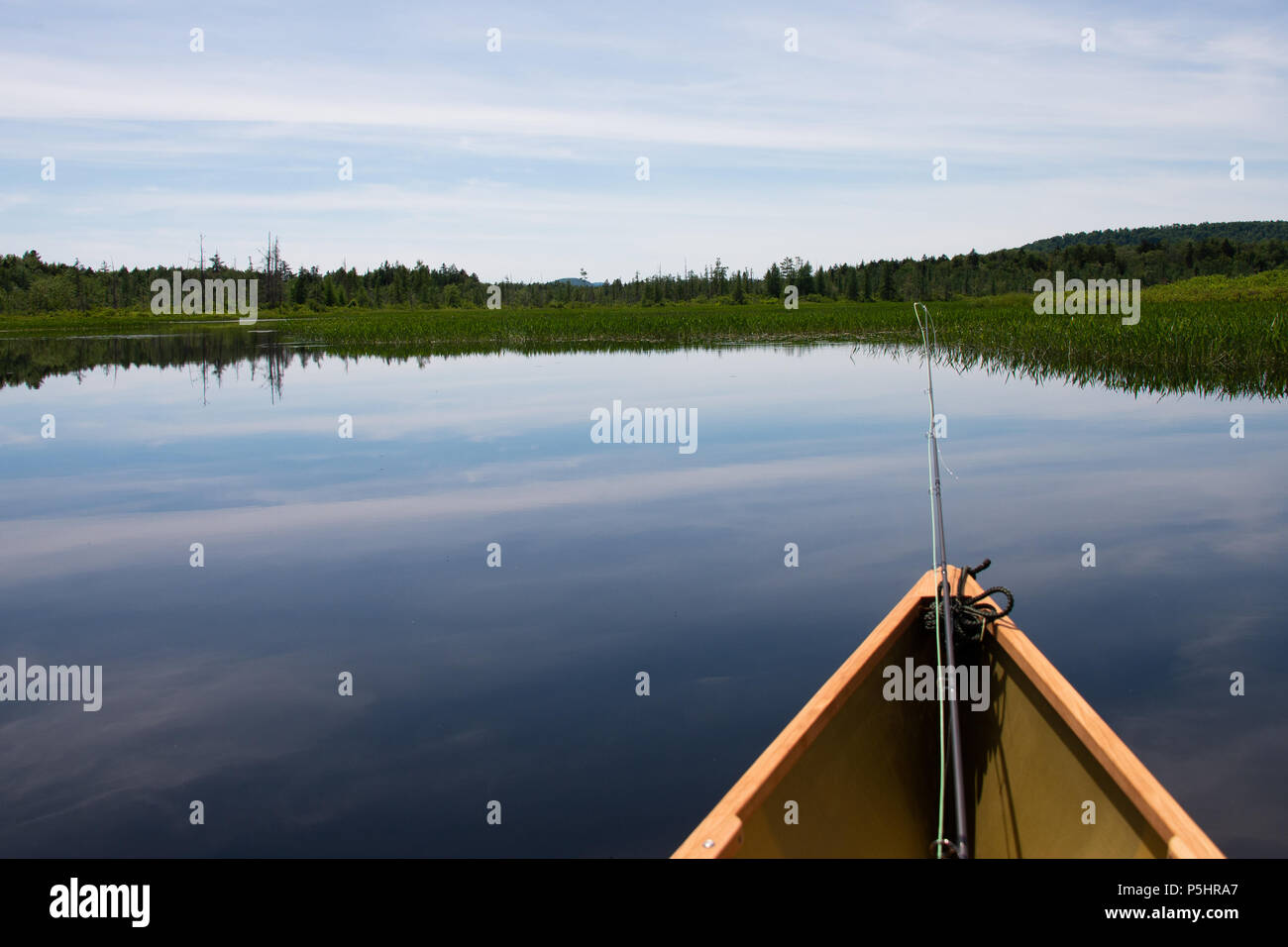 A lightweight Kevlar canoe with a fly fishing rod floating on Kunjamuk