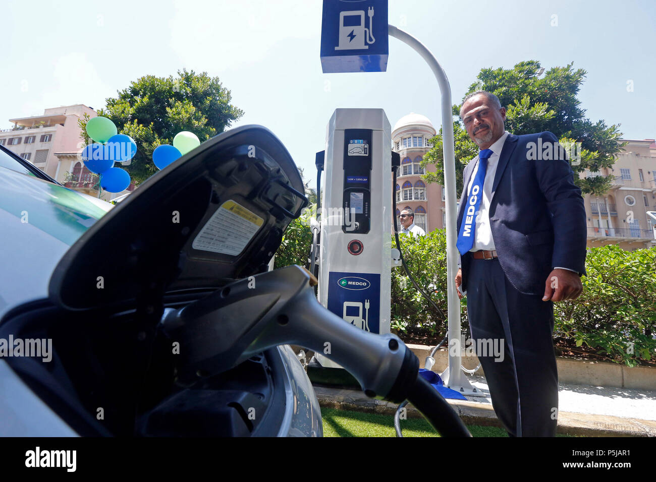 Beirut, Lebanon. 27th June, 2018. A staff memeber of MEDCO charges an electrical car in downtown Beirut, Lebanon, on June 27, 2018. Lebanese company MEDCO inaugurated four charging stations for electrical cars. Credit: Bilal Jawich/Xinhua/Alamy Live News Stock Photo