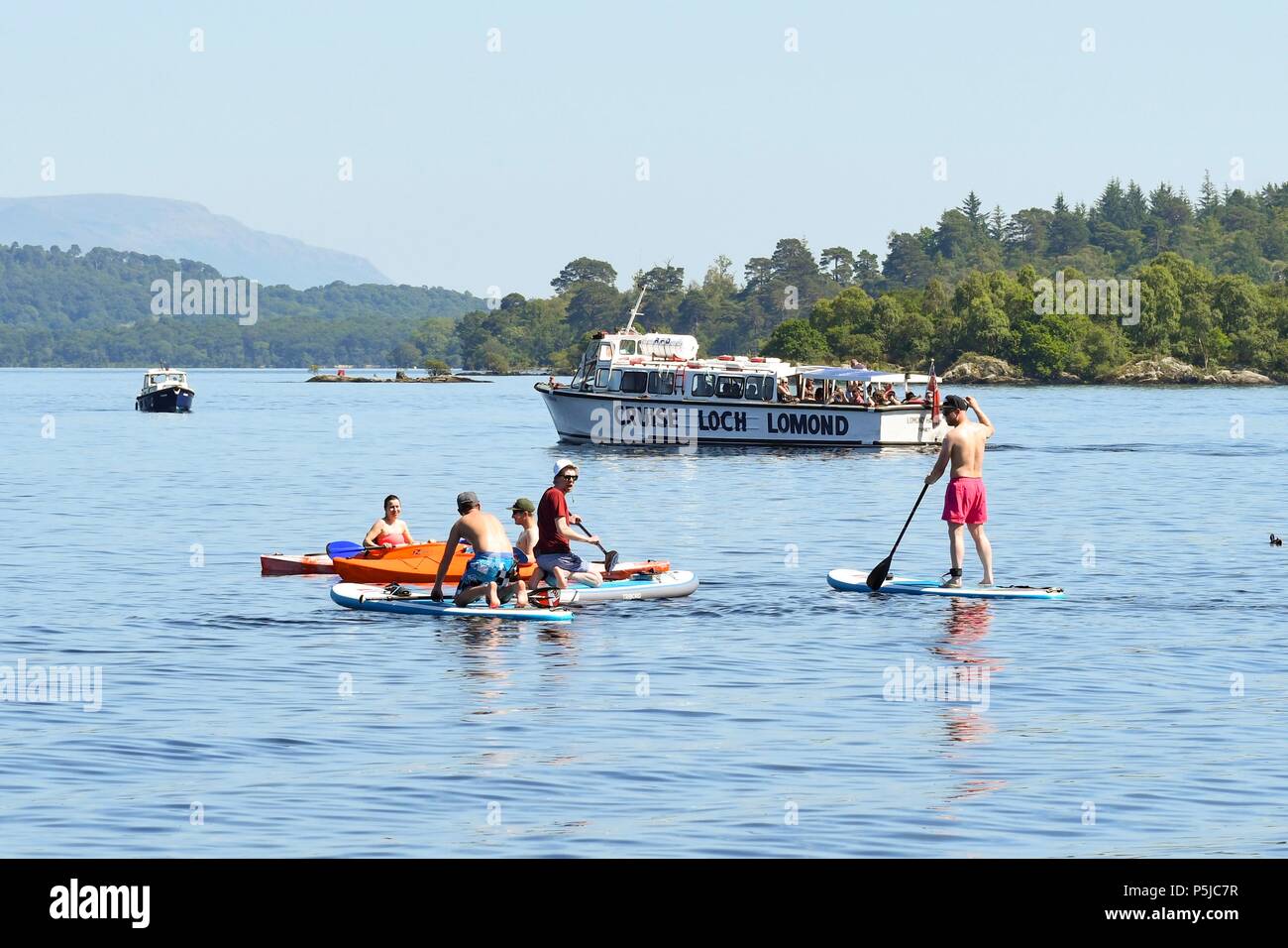 Luss, Loch Lomond, Scotland, UK - 27 June 2018: uk weather - Crowds flock to Luss to enjoy the beach and water sports as the temperature continues to rise Credit: Kay Roxby/Alamy Live News Stock Photo