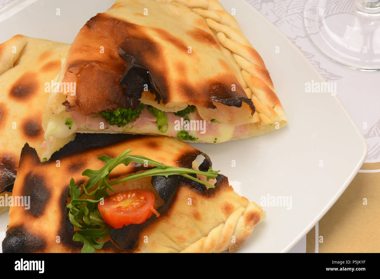 Close-up closed italian pizza calzone on white plate Stock Photo