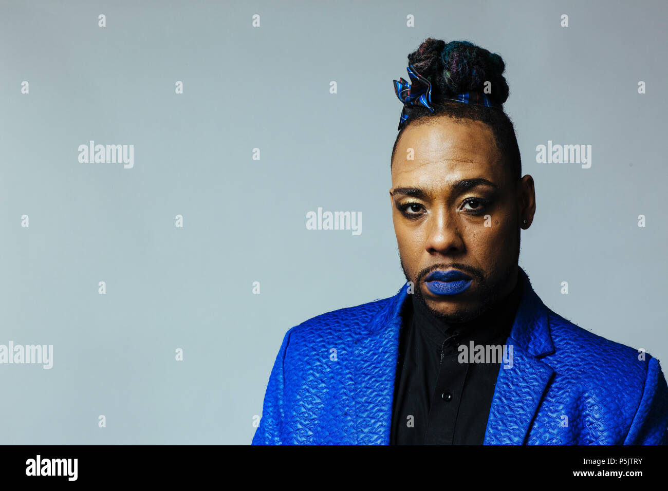 Portrait of a cool man in blue jacket and blue lips Stock Photo