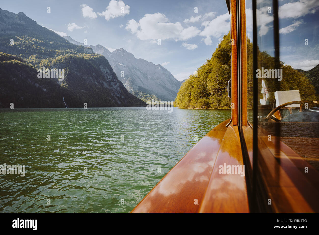 Traditional passenger boat gliding on Lake Konigssee with Watzmann mountain in the background on a beautiful sunny day in summer, Berchtesgadener Land Stock Photo
