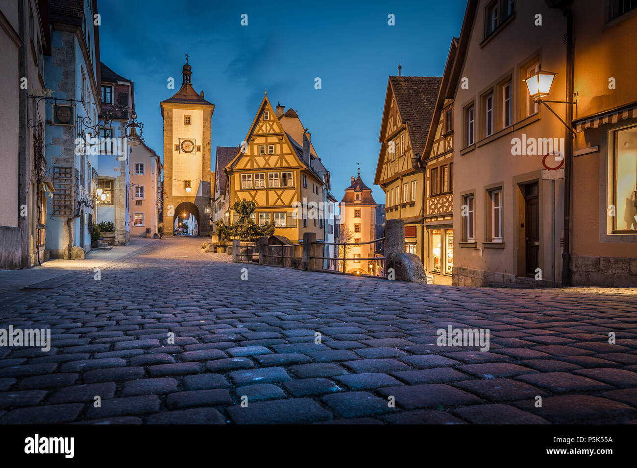 Classic view of the medieval town of Rothenburg ob der Tauber illuminated in beautiful evening twilight during blue hour at dusk, Bavaria, Germany Stock Photo