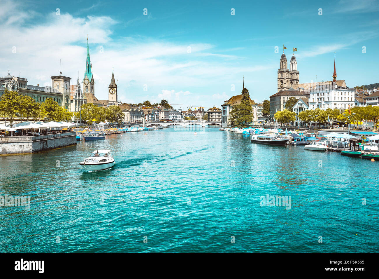 Panoramic view of Zurich city center with churches and boats on beautiful river Limmat in summer, Canton of Zurich, Switzerland Stock Photo