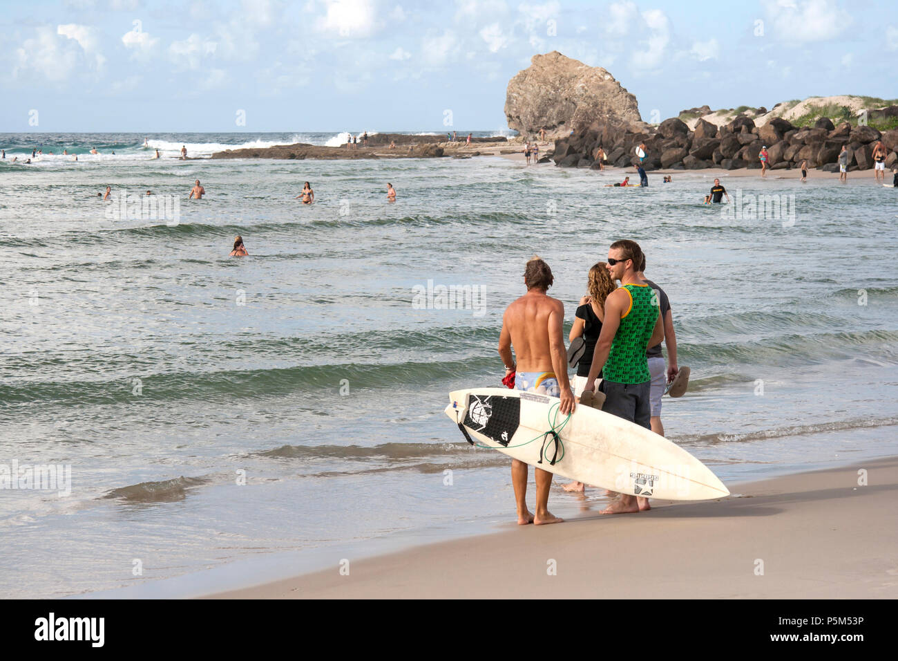 Surfers enjoying the outdoors, watching the ocean and the swimmers and at Currumbin Rocks, Gold Coast, Queensland, Australia Stock Photo