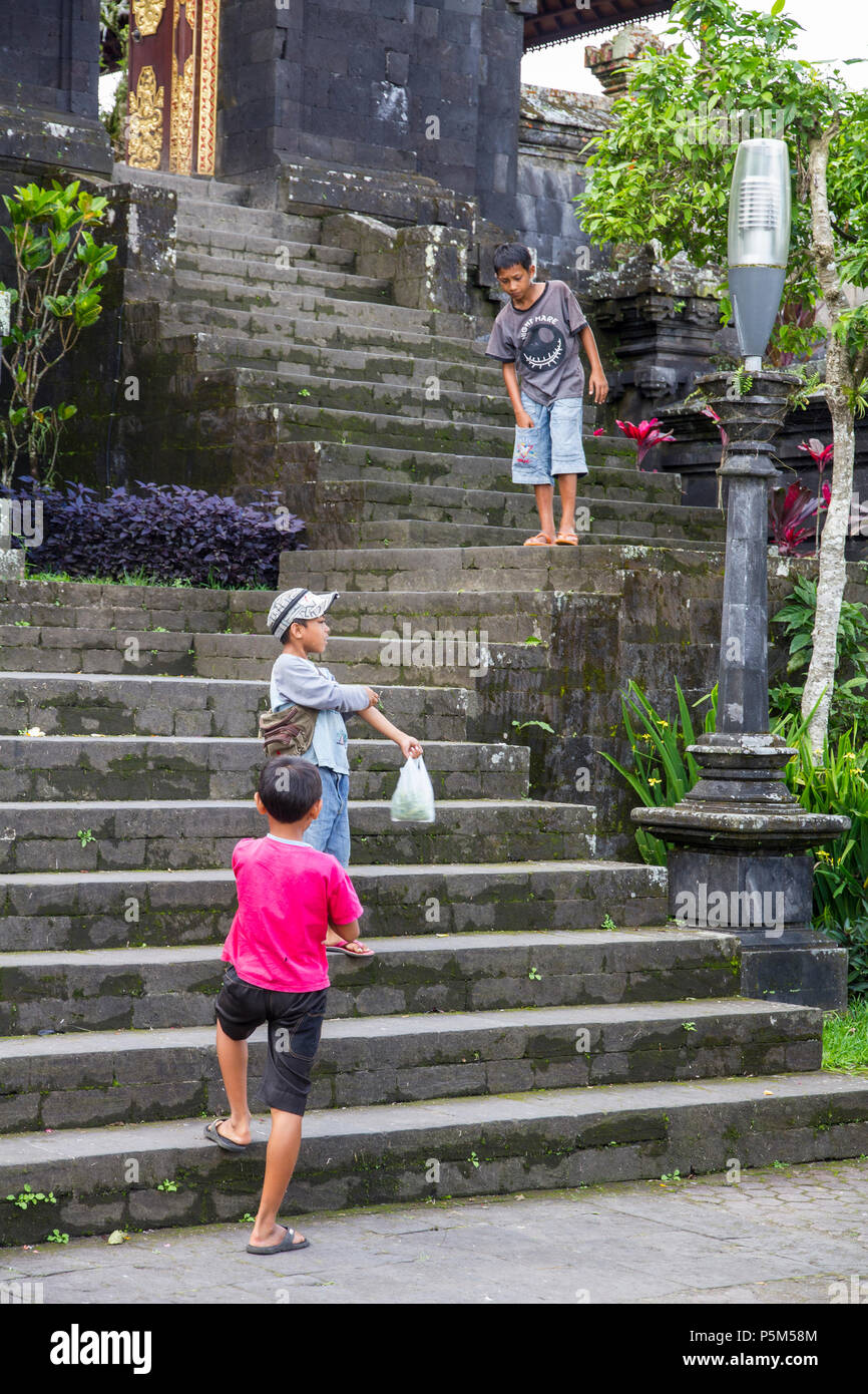 Boys playing on the steps of Besakih Temple, perched 1000m high on the Southwestern slopes of Mt Agung, Bali (also Mother Temple or Pura Besakih) Stock Photo