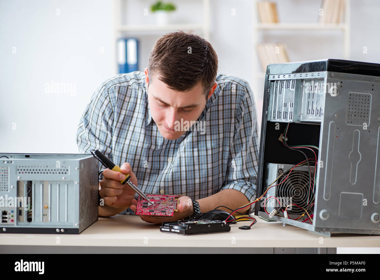 Young technician repairing computer in workshop Stock Photo - Alamy