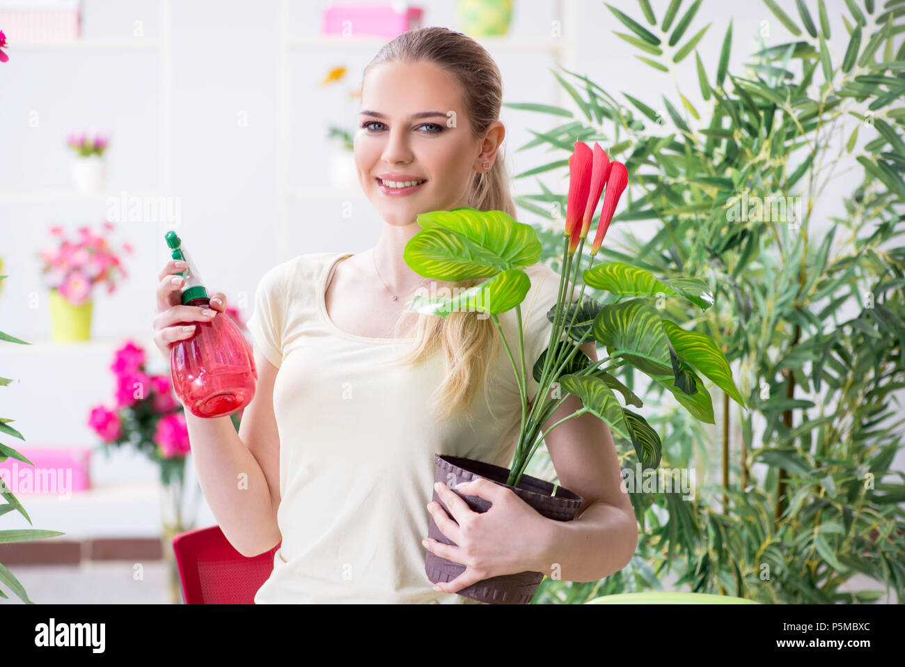 Young woman watering plants in her garden Stock Photo - Alamy
