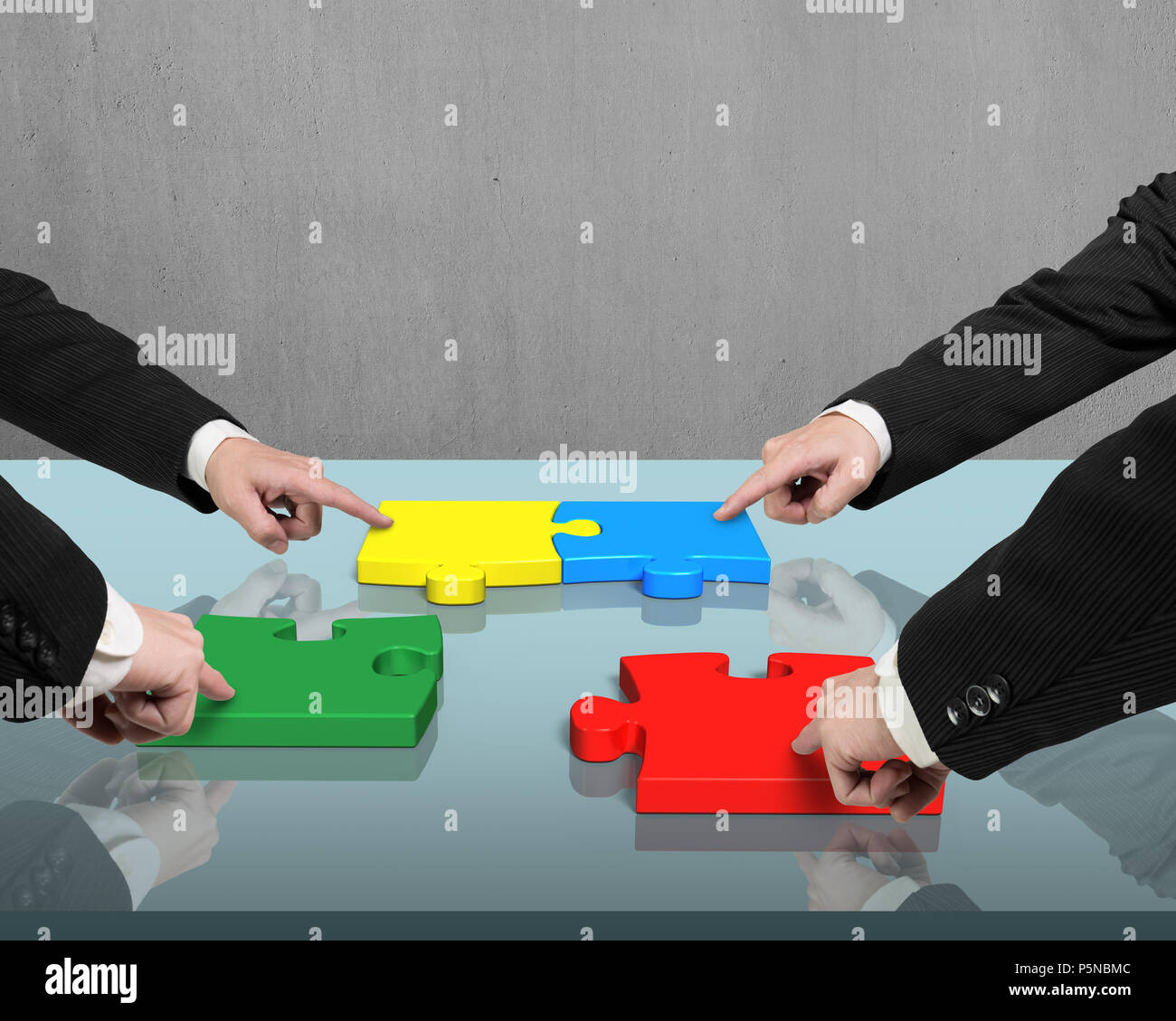 Putting four puzzles together on office table Stock Photo Alamy