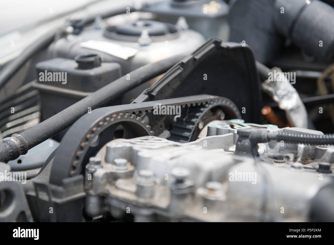 The timing belt of an automobile engine is visible on the side of the engine. Stock Photo
