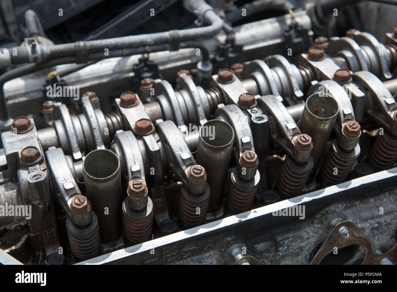 An open engine block with rusted bolts reveals the four cylinders of
