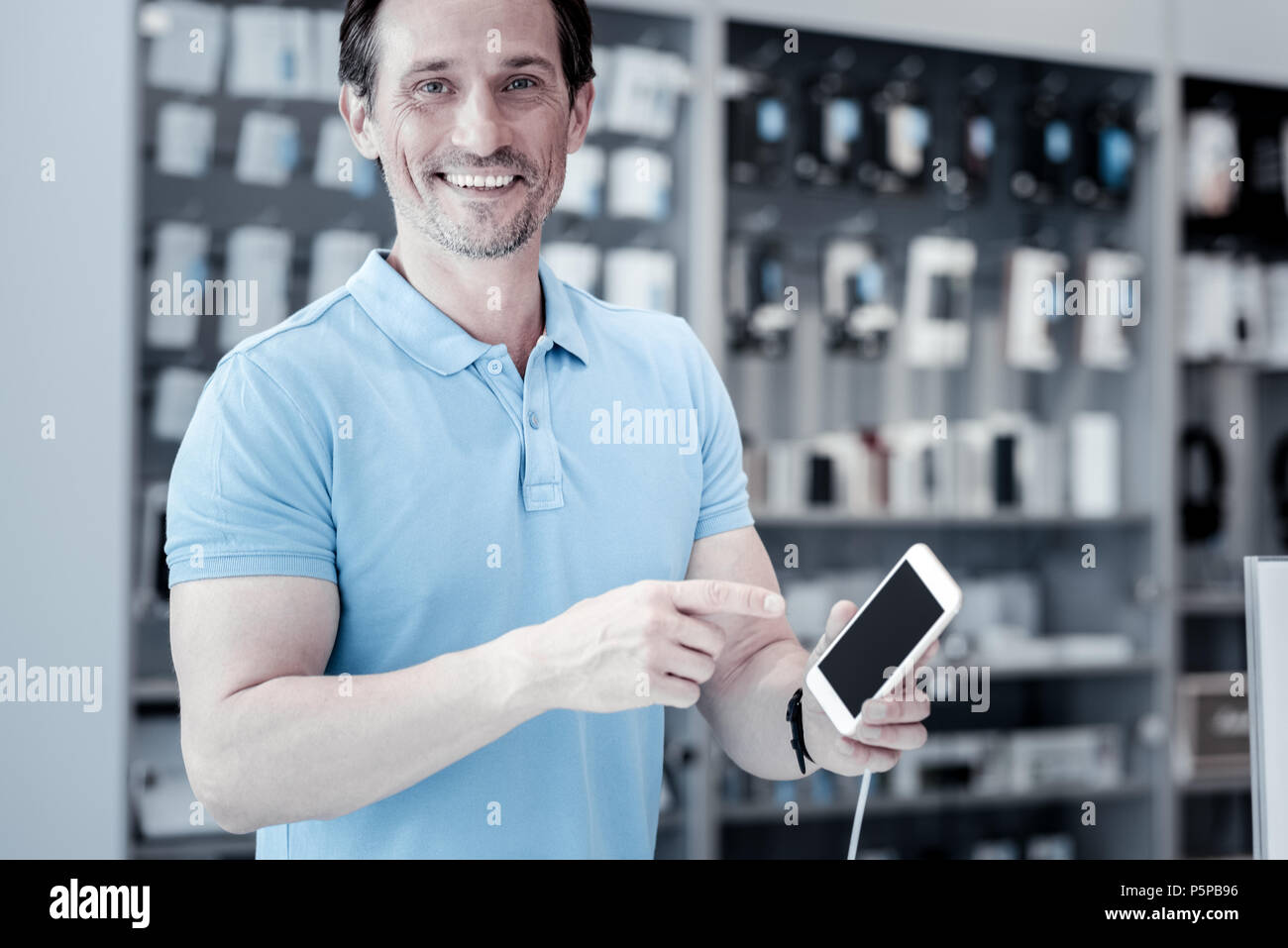 Happy smiling man pointing at the smartphone Stock Photo