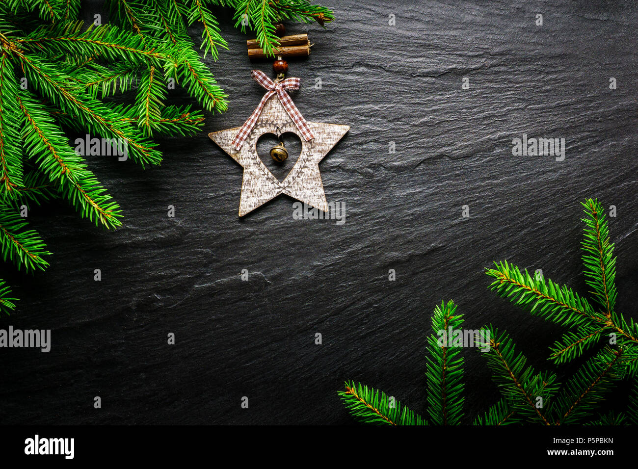 Christmas background. Fir tree with wooden star on dark slate table. Top view with copy space. Stock Photo