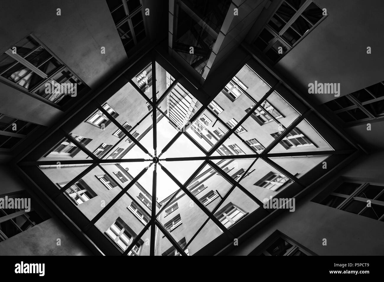 Tallinn, Estonia - May 1, 2016: Interior of old living house courtyard covered with glass roof, black and white photo Stock Photo