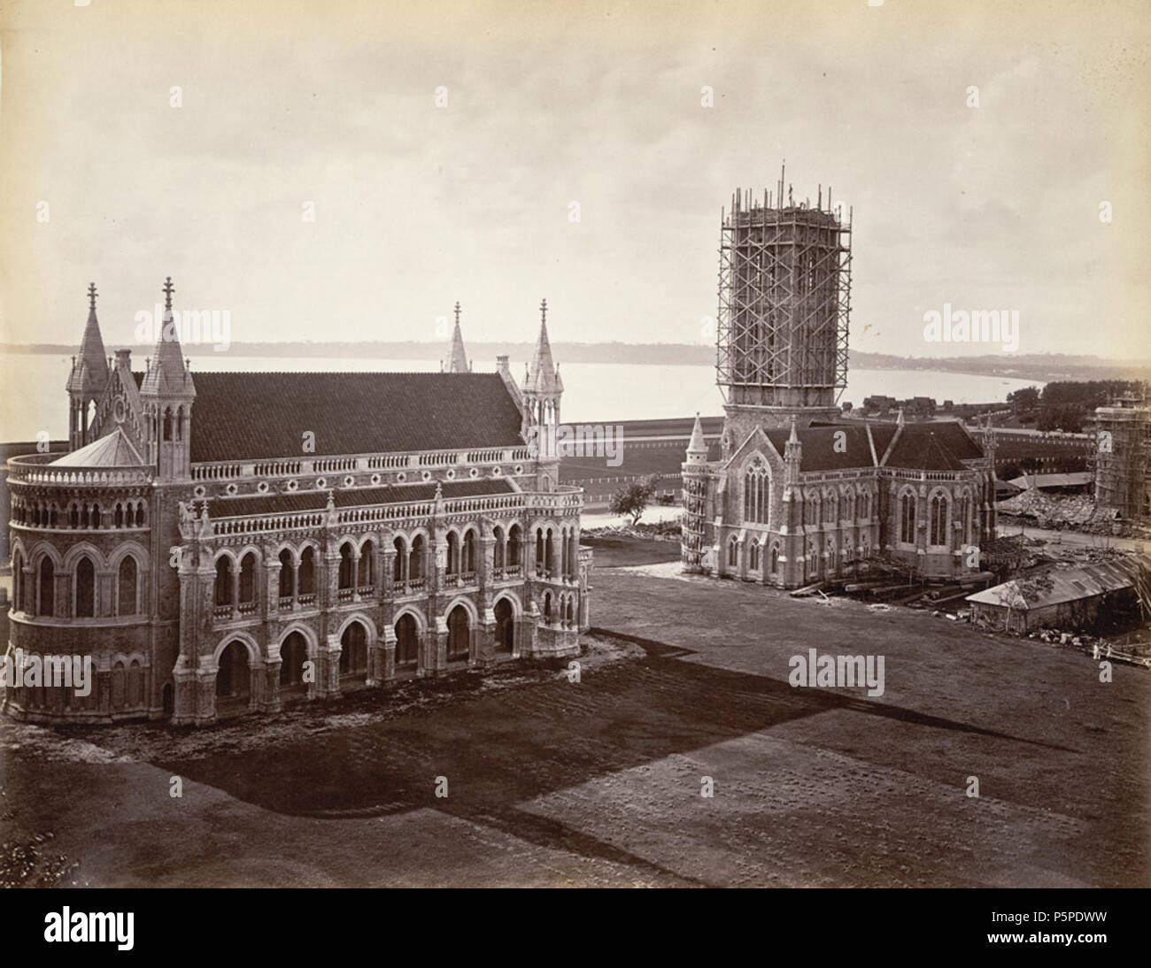 N/A. English: Photograph of the Bombay University buildings, taken by an unknown photographer in the 1870s in Bombay (Mumbai), Maharashtra, from an album of 40 prints mostly dating from the 1860s. Bombay, the capital of Maharashtra and one of India's major industrial centres and a busy port, was originally the site of seven islands on the west coast, sparsely populated by Koli fisherfolk. Bombay was by the 14th century controlled by the Gujarat Sultanate who ceded it to the Portuguese in the 16th century. In 1661 it passed to the English as part of the dowry brought to Charles II by the Portug Stock Photo