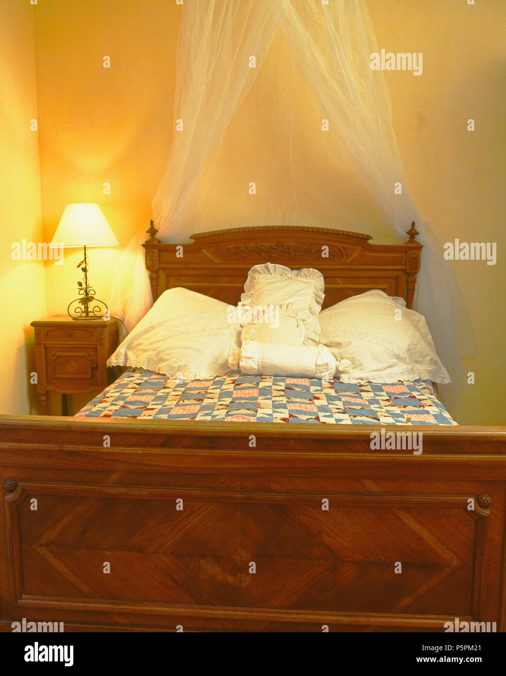 Lighted Lamp On Table Beside Vintage Wooden Bed With White