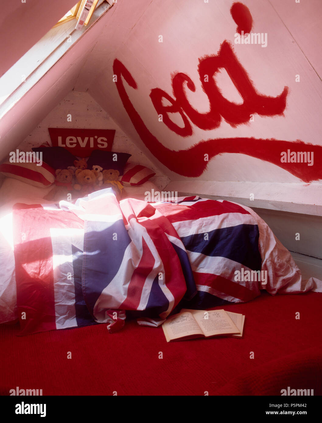 Coca' sign painted on ceiling in economy-style teenage bedroom with Union Jack flag covering the bed Stock Photo