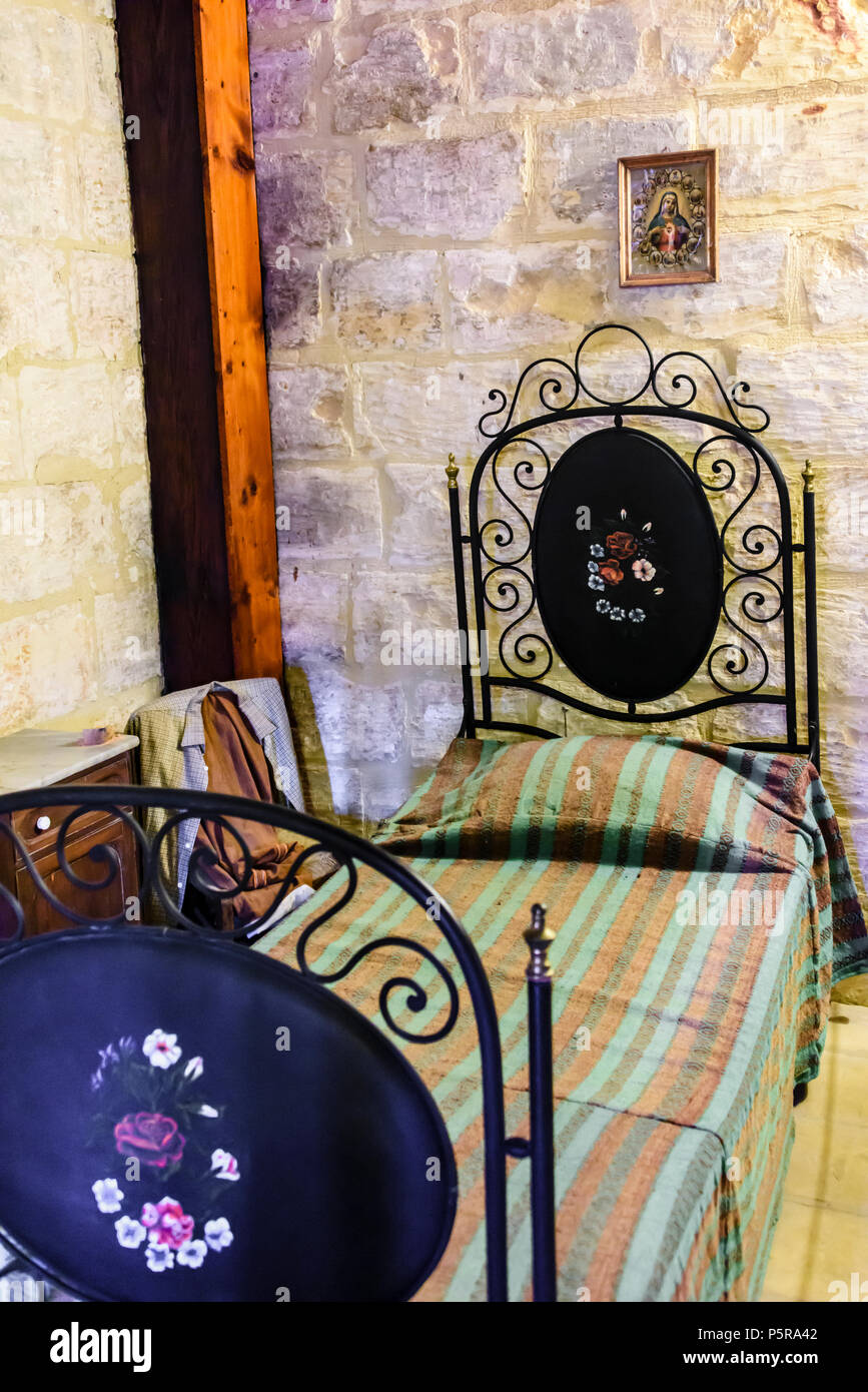 Traditional bedroom with Roman Catholic pictures and crucifixes in a Maltese house. Stock Photo