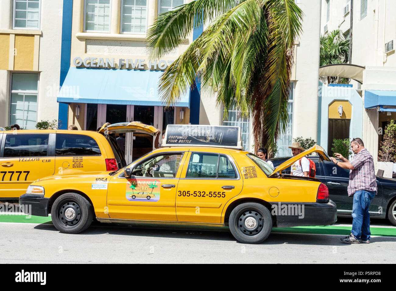 Miami Beach Florida,Ocean Drive,Ocean Five Hotel,Art Deco hotel,exterior,taxi taxis cab cabs,dropping off rider riders,unloading luggage,Black man men Stock Photo