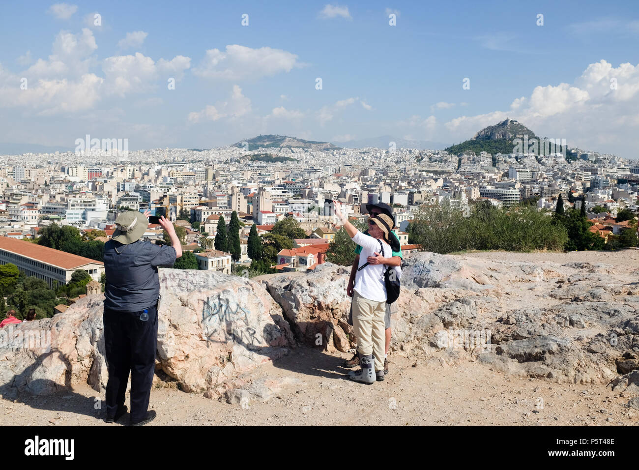 Tourists taking Photos/Selfies from the Acropolis, enjoying the views of Athens and Mount Lycabettus ( Lycabettos ), Athens, Greece. Stock Photo