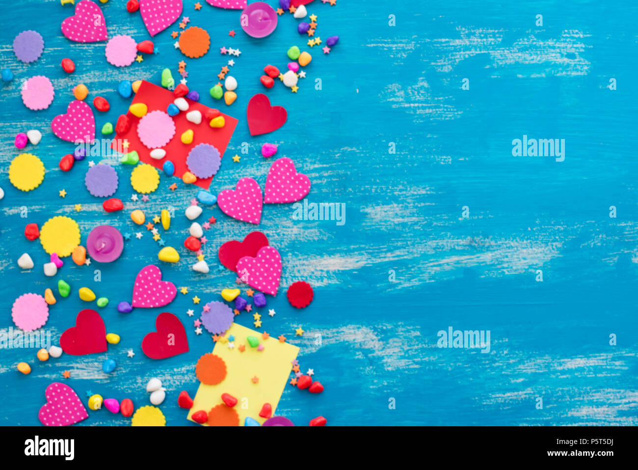Defocus Festive confetti background heart candy color saturated. Wood old blue background with copy space flat lay Stock Photo