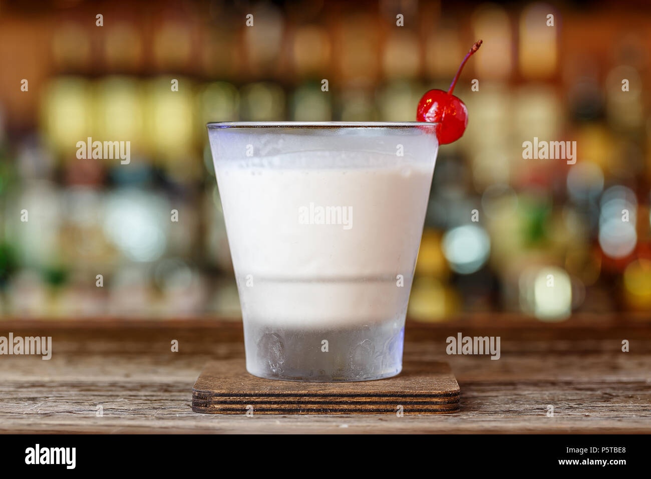 White Russian cocktail stands on the bar in the restaurant on a blurry bottle background Stock Photo