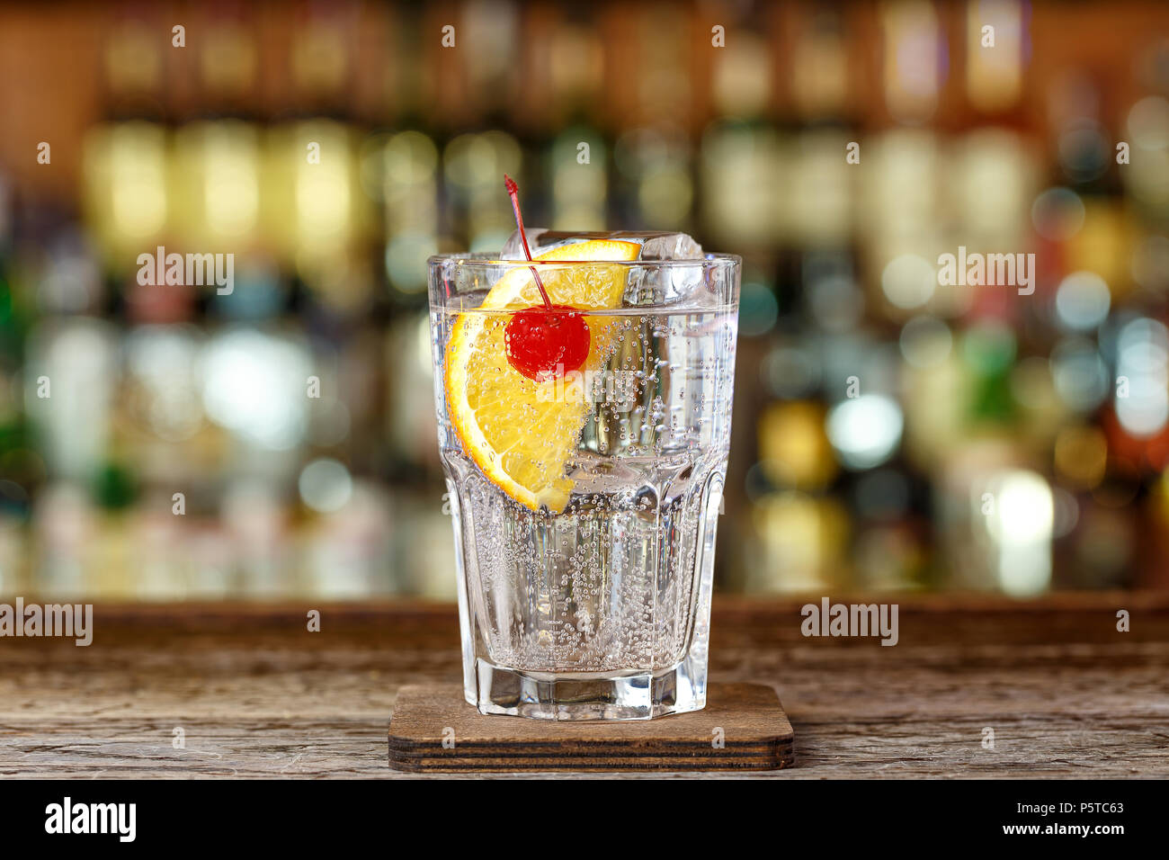 Cocktail tom collins, a classic drink recipe with gin, lemon juice and  sugar syrup. In a lemon slice and cherry cocktail Stock Photo - Alamy