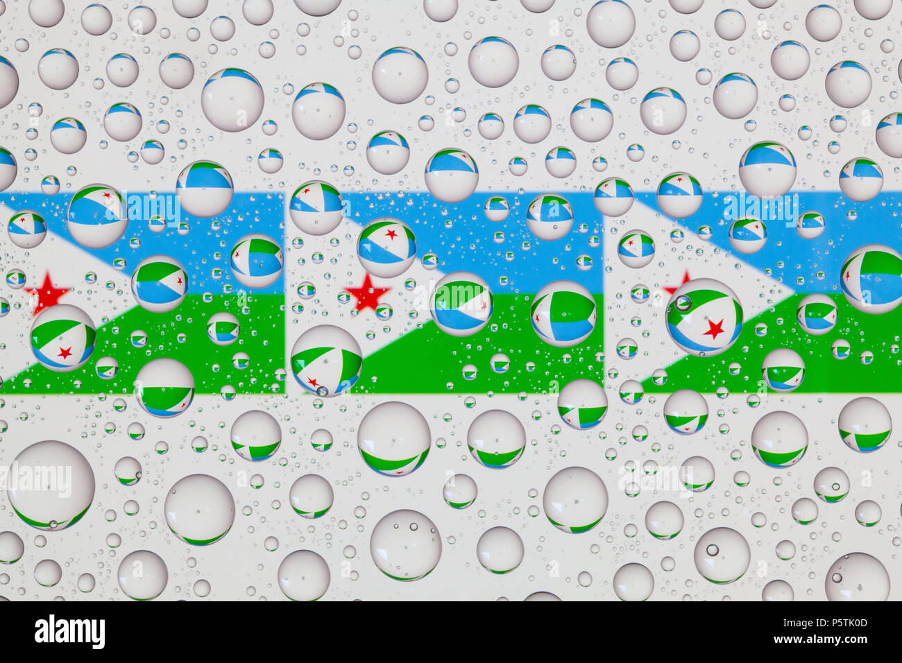Flags  of Djibouti behind a glass covered with raindrops. Stock Photo