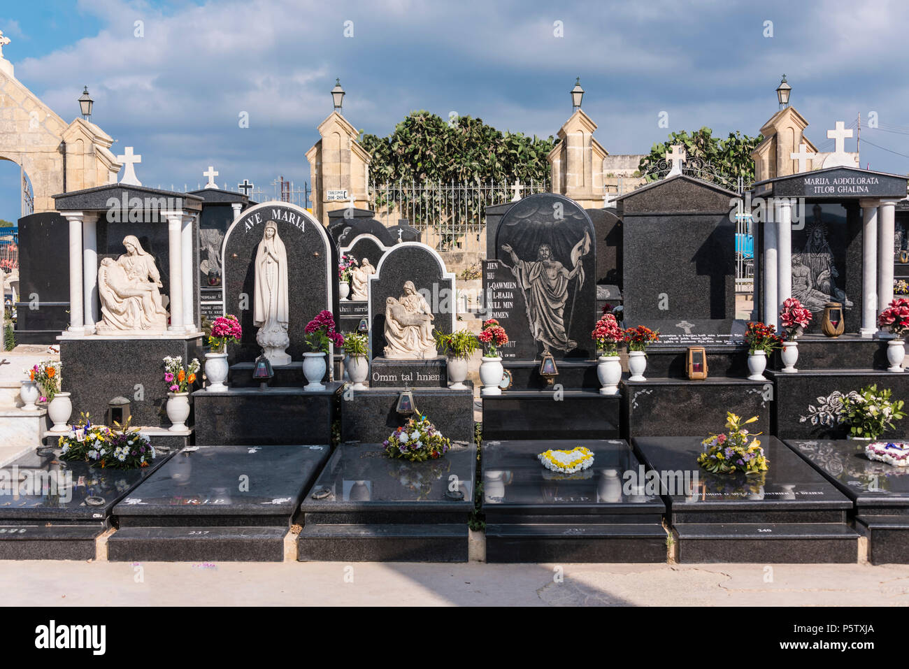 Roman Catholic cemetery with ornate carved marble and granite headstones, Xwekija, Gozo, Malta. Stock Photo