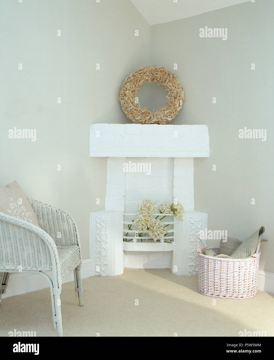 Vintage Lloyd Loom chair beside corner fireplace white painted firegrate and mantle with shell