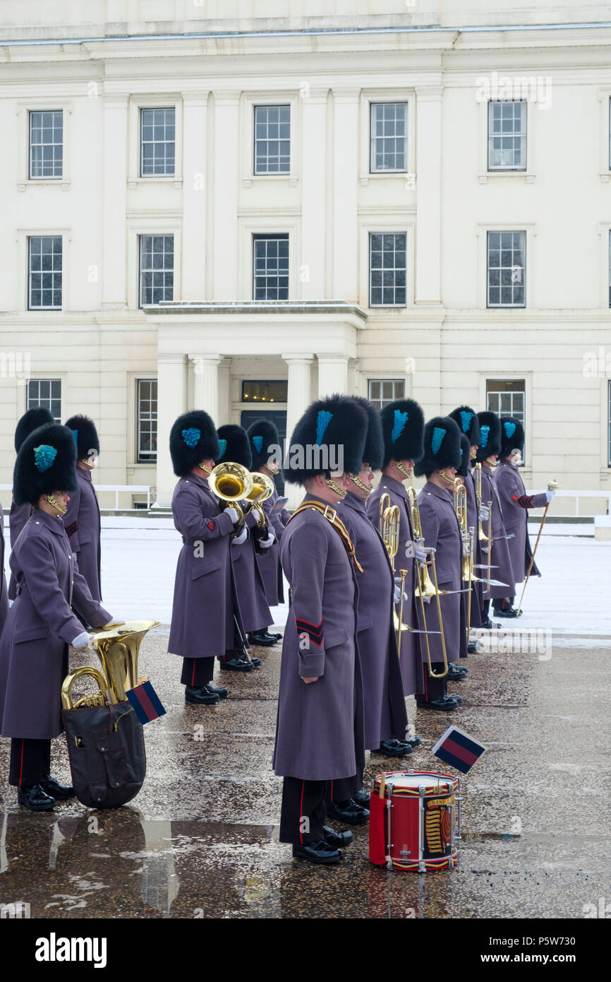 Irish guard foot soldiers of the Household Division of the Queen's Guard at the Changing of the Guard ceremony in London, in the snow Stock Photo